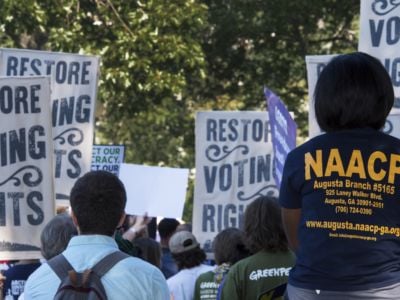 Protesters backs are seen as they march for voting rights