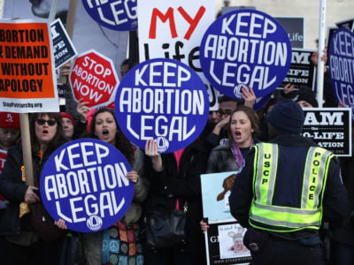 Pro-choice activists shout slogans before the annual March for Life passes by the U.S. Supreme Court January 22, 2015, in Washington, D.C. Anti-choice activists gathered in the nation's capital to mark the 1973 Supreme Court decision that legalized abortion.