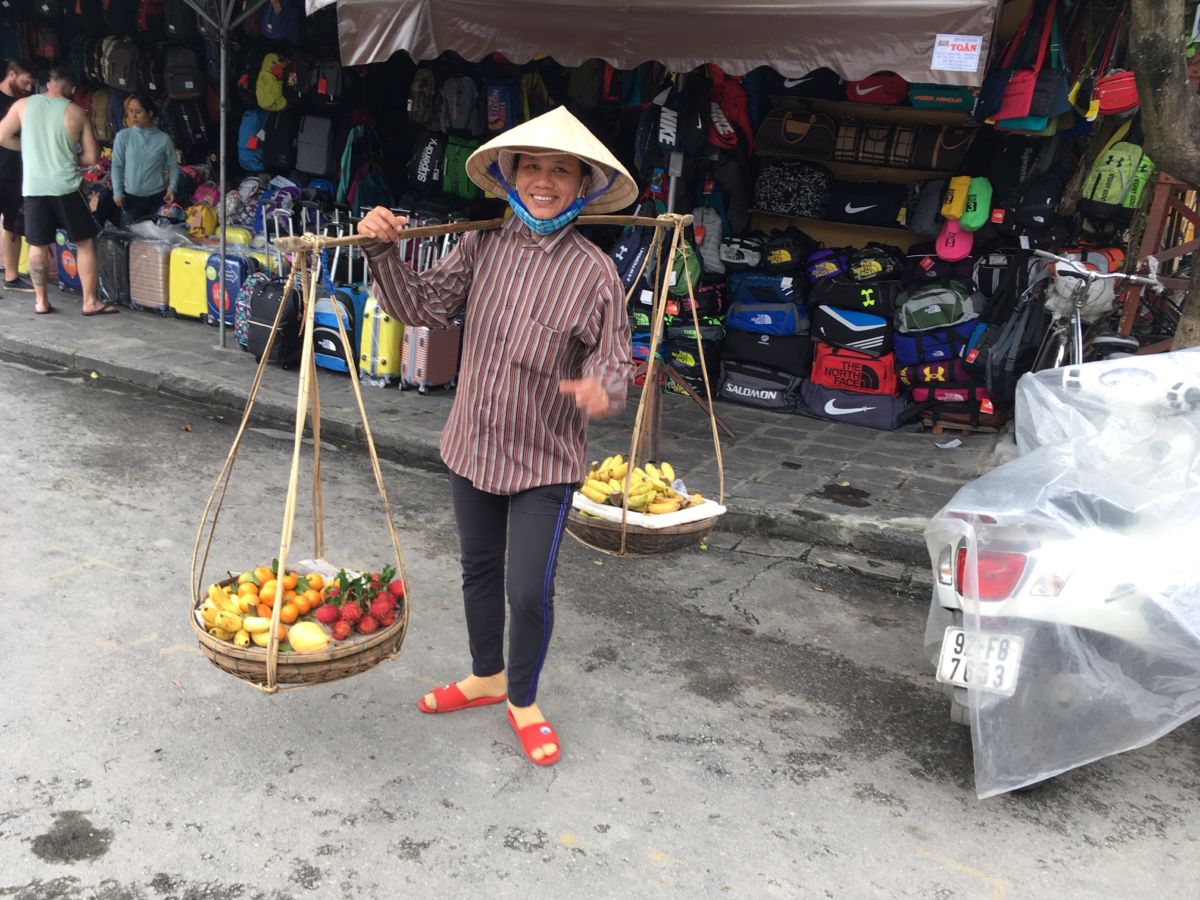 A person carries produce in a market