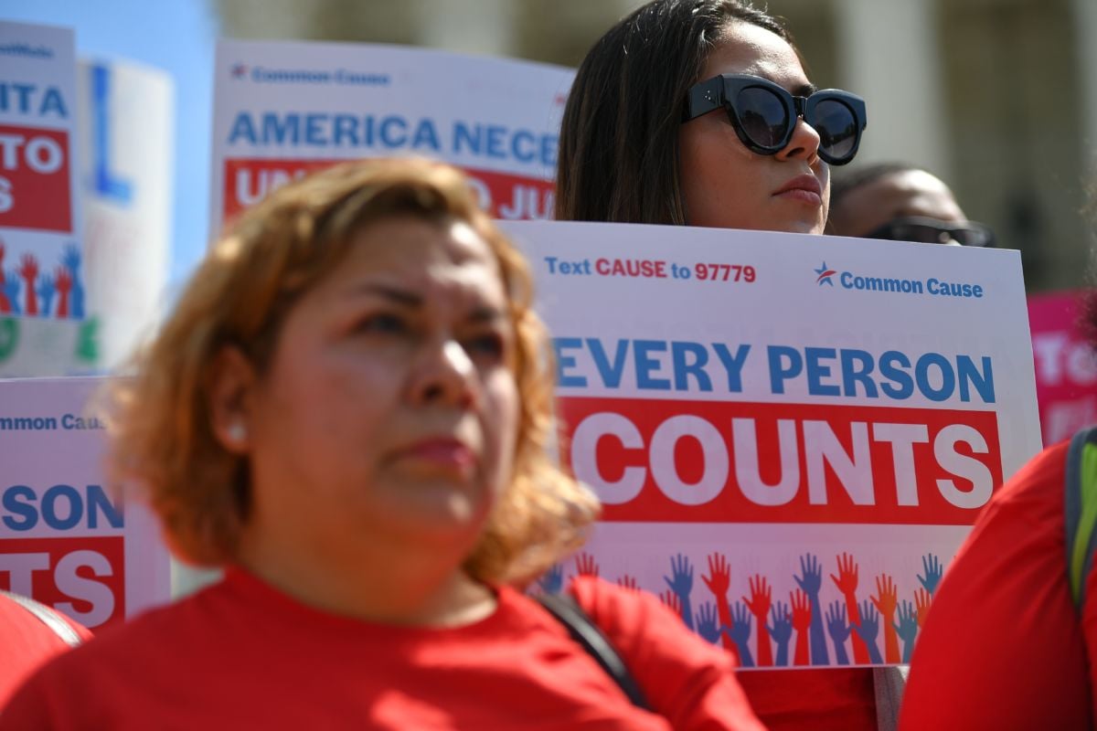 A woman holds a sign reading "EVERY PERSON COUNTS" during a protest, census