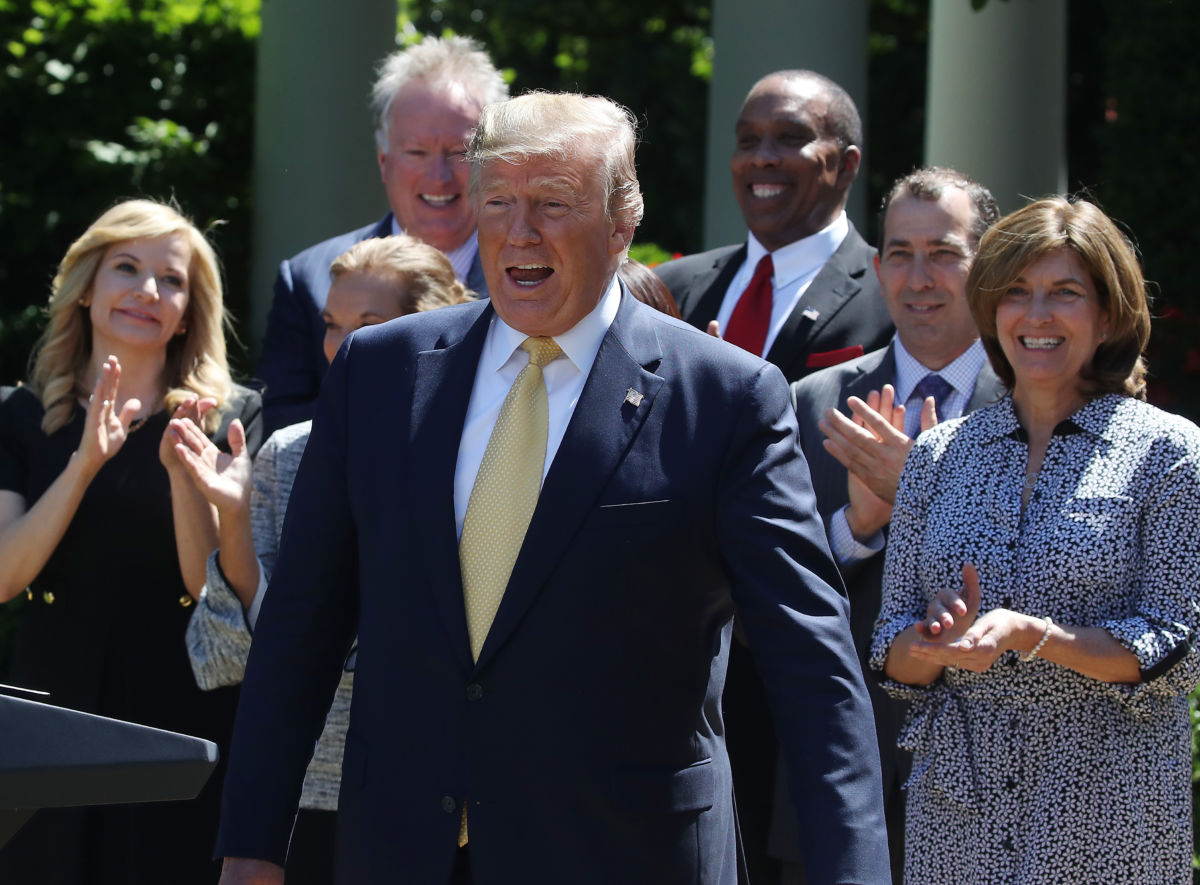 Donald Trump walks toward a podium as people beghind him clap