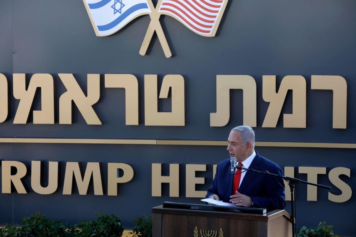 Benjamin Netanyahu stands in front of a sign reading "TRUMP HEIGHTS"
