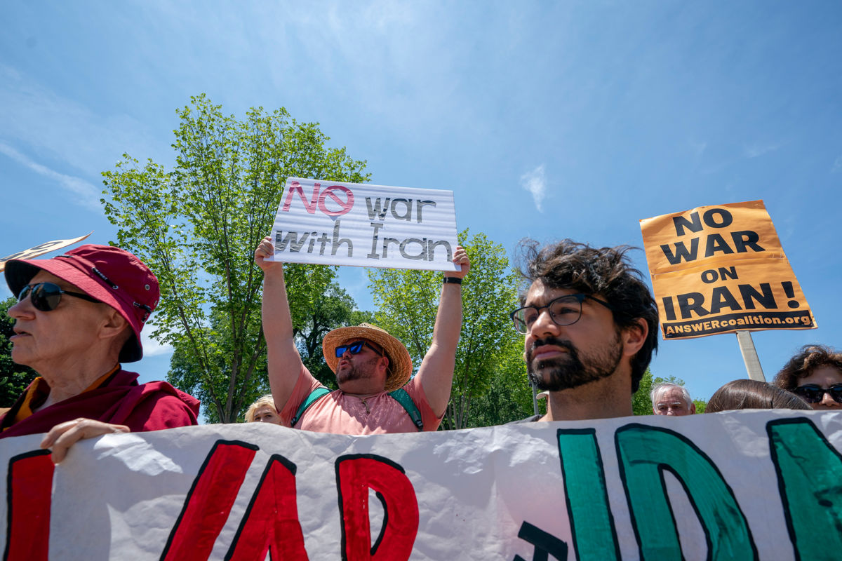 Protesters against war with Iran display signs during an action