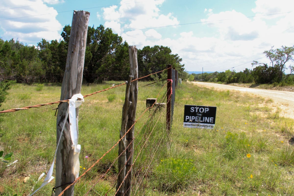A sign displayed on Mark Weiler's land in Blanco, Texas, on May 16, 2019. In the foreground, Kinder Morgan’s survey marker is seen.