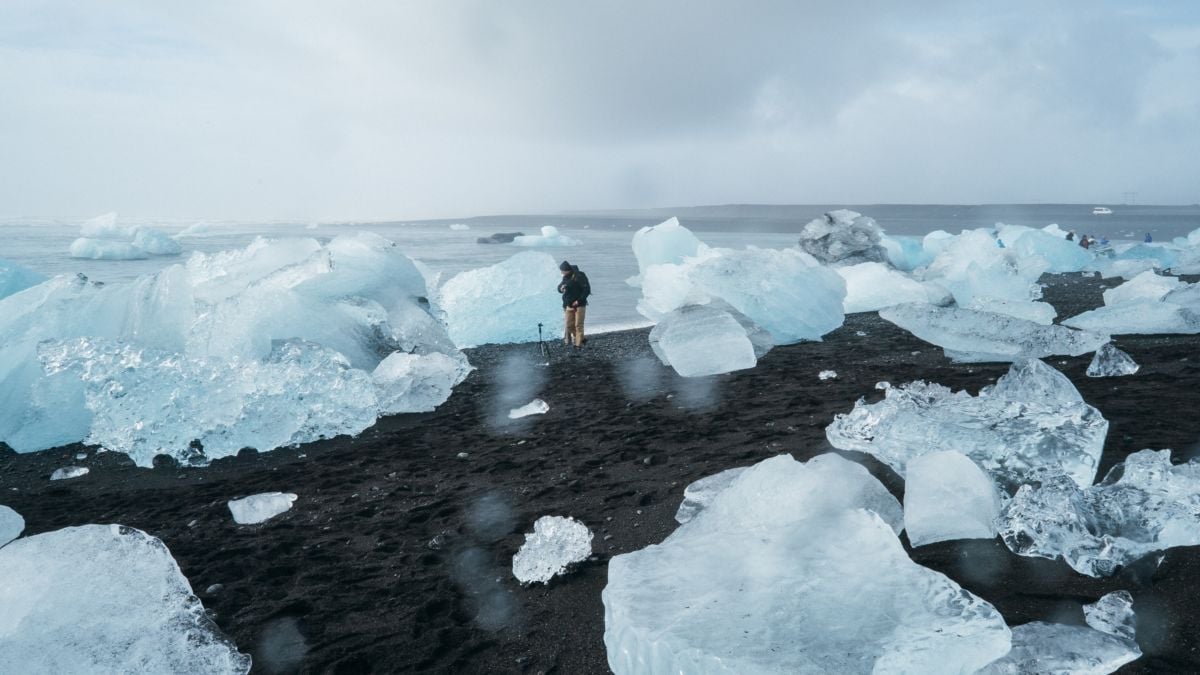 A man takes photos amidst hunks of sea ice