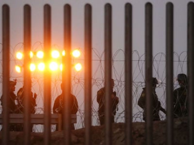 U.S. Border Patrol agents stand watch on the U.S. side of the U.S.-Mexico border fence at dusk on November 26, 2018, in Tijuana, Mexico.