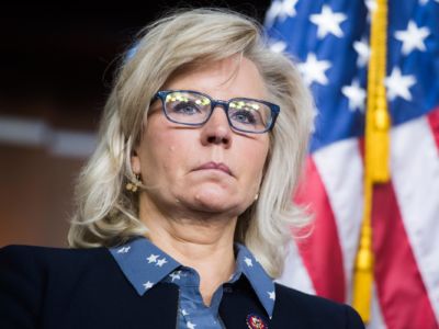 Liz Cheney stands in front of a U.S. flag