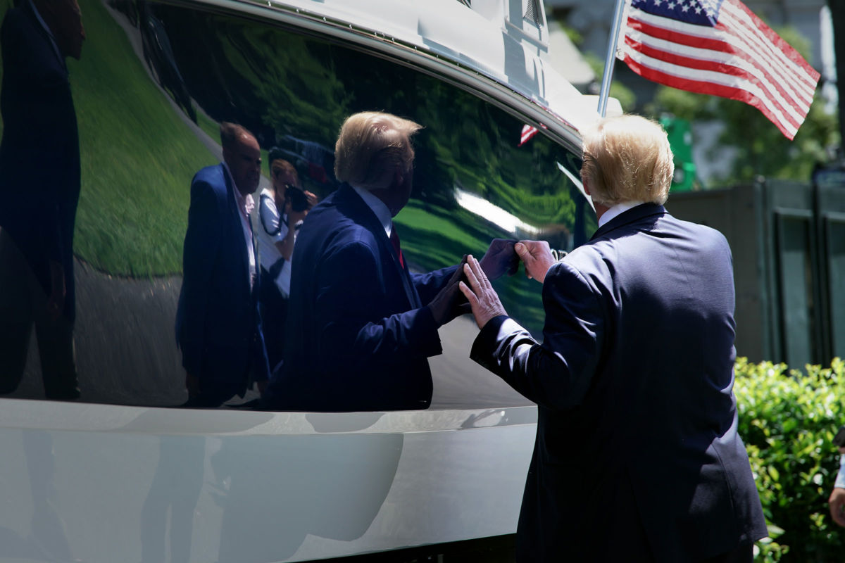 President Trump knocks on the hull of a power boat as he tours his 'Made In America' product showcase at the White House, July 15, 2019, in Washington, D.C.