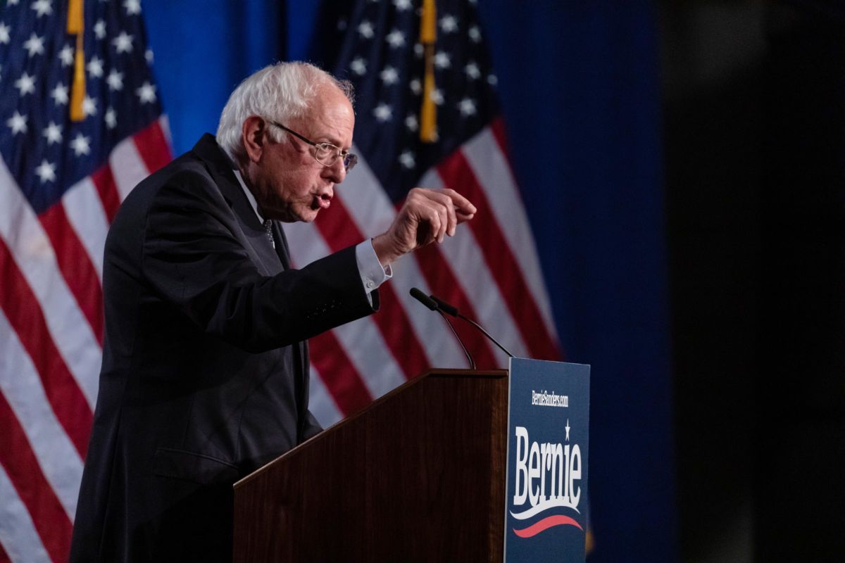 Bernie Sanders points towards the audience while speaking at a podium