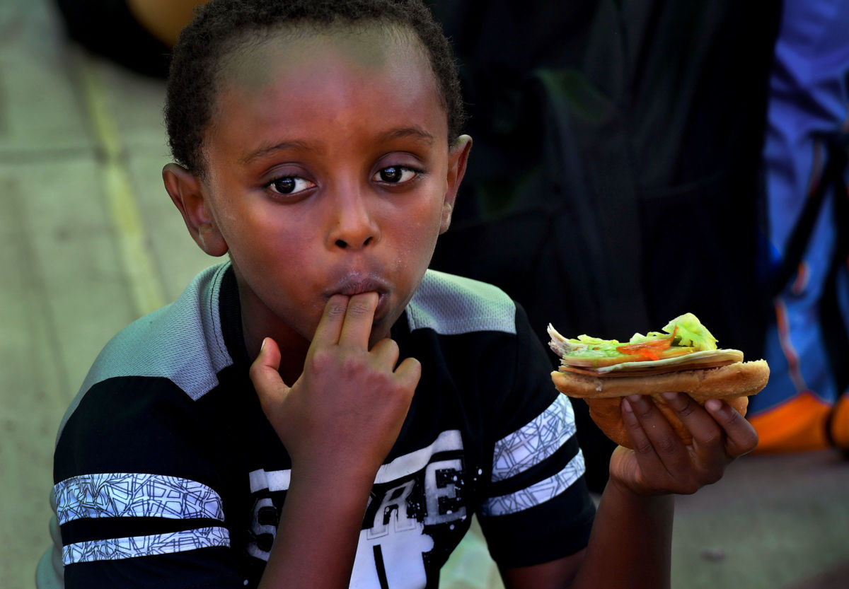 A young boy eats a sandwich
