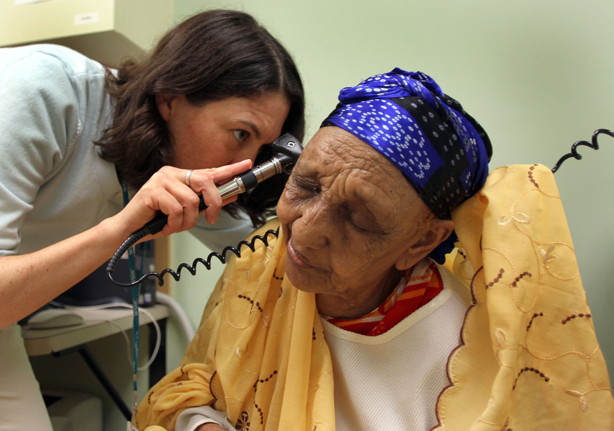 A doctor examines the inner ear of an elderly patient