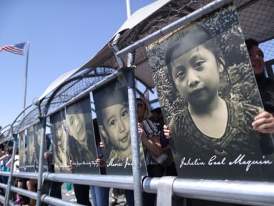Activists hold photos of migrant children who died trying to cross the U.S.-Mexico border, as they demonstrate standing on the Paso Del Norte Port of Entry bridge, on June 27, 2019, in Ciudad Juarez, Mexico.