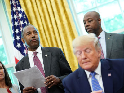 Ben Carson stands behind Donald Trump and speaks