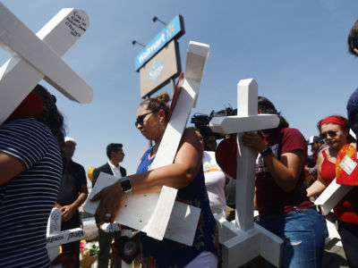 Volunteers carry handmade crosses memorializing the victims of a mass shooting to a makeshift memorial outside Walmart, where the shooting took place, on August 5, 2019, in El Paso, Texas.