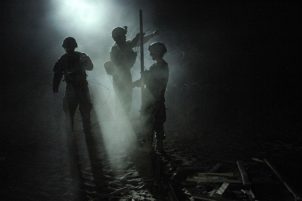 U.S. soldiers fortify an Afghan Highway Police checkpoint with razor wire in Robat, Afghanistan, March 19, 2010.