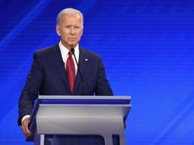 Joe Biden frowns while standing at a podium