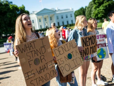 teens display signs opposing climate change outside of the white house