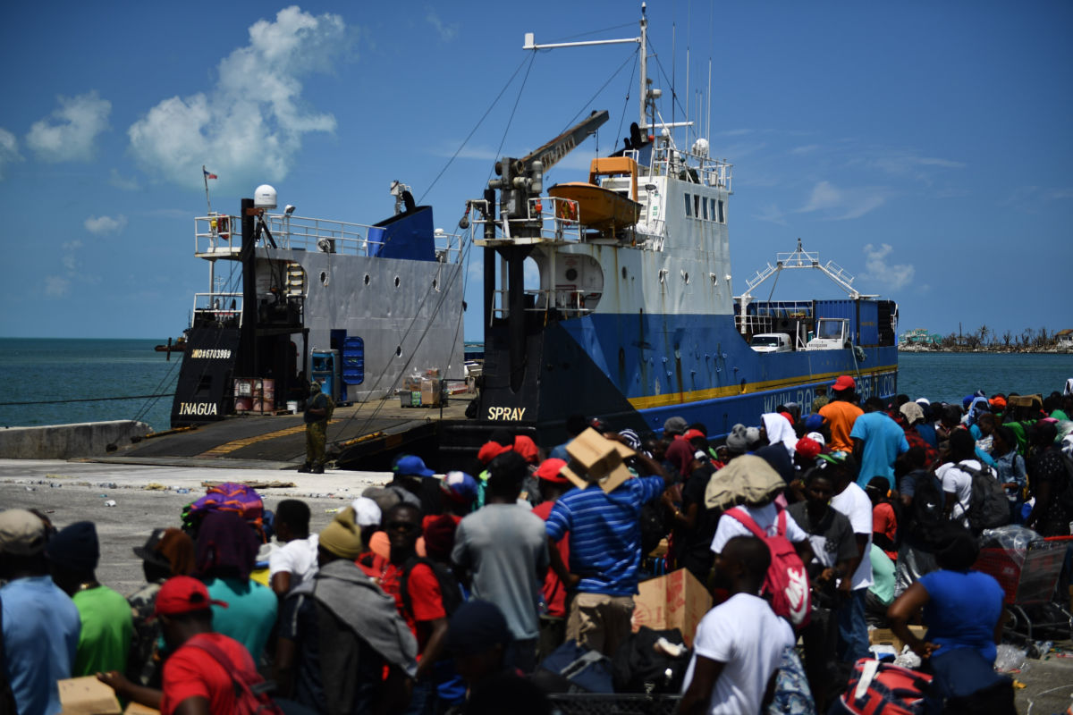 People wait on a dock to be able to board a ship to the U.S.