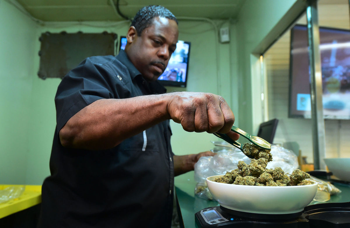 Eddie Irby weighs the marijuana at Virgil Grant's dispensary in Los Angeles, California