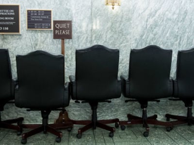 Empty chairs and a quiet please sign sit outside the Senate Committee on Appropriations hearing room in the Dirksen Senate Office Building on July 30, 2019.