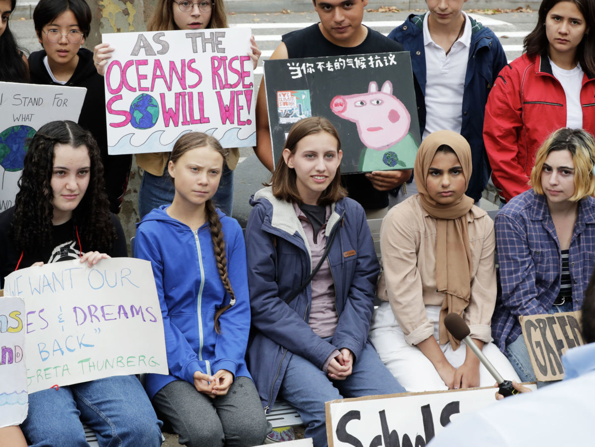 Greta Thernberg sits among a group of other young activists