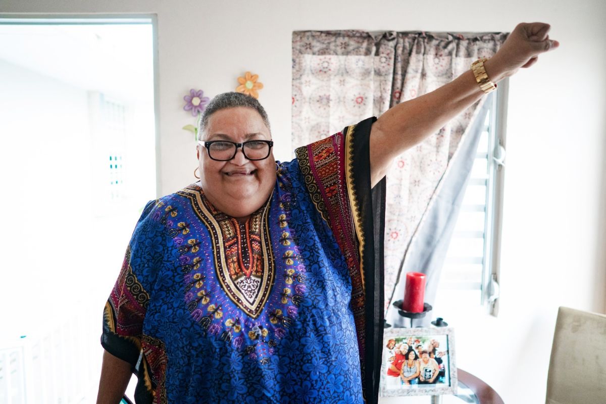 Mirta Colón Pellicier raises her fist in her Section 8 apartment in San Juan, Puerto Rico, in March 2019.