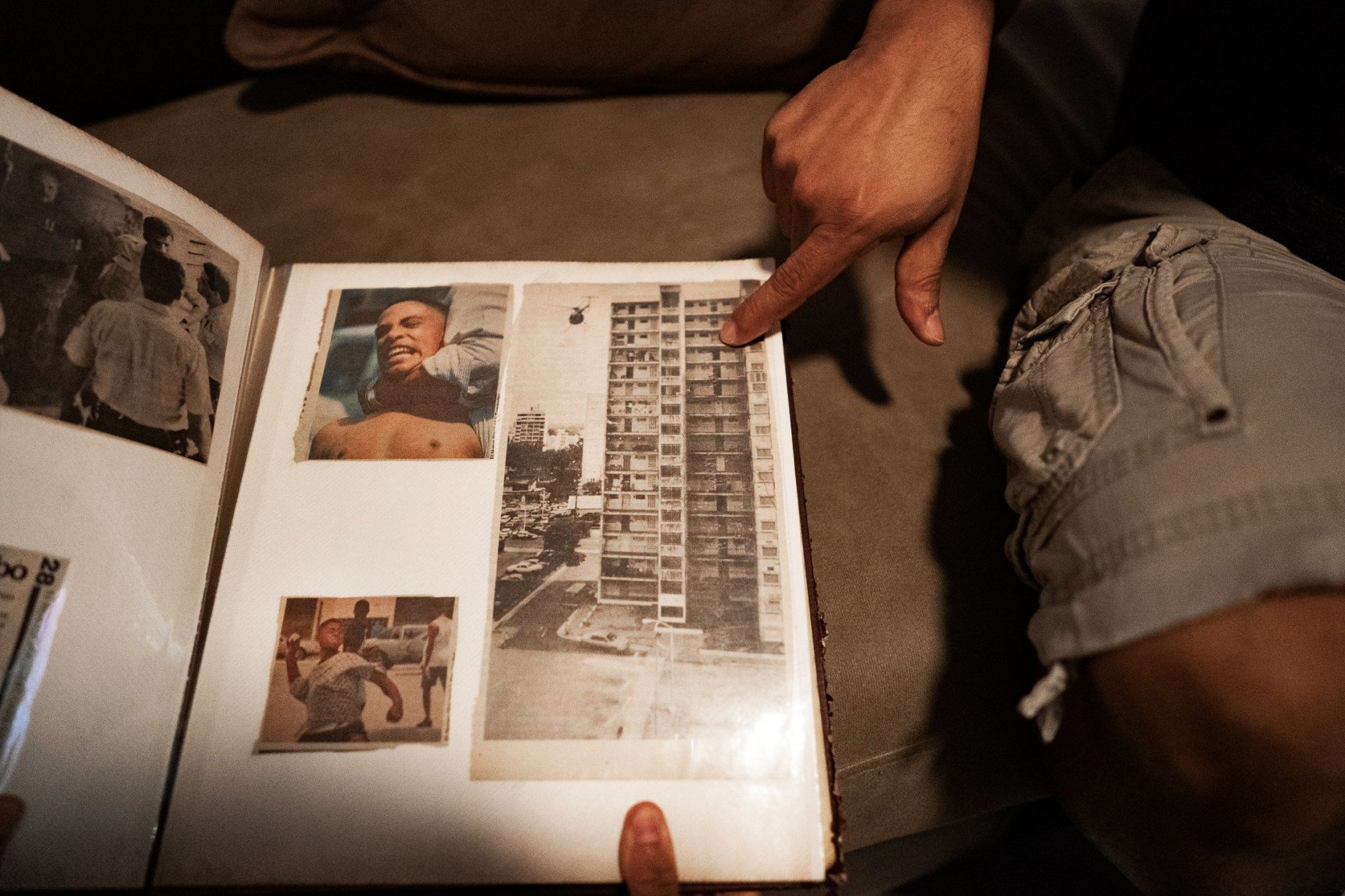 A former resident of Las Gladiolas shows newspaper clippings in a scrapbook documenting the raids at the complex in the 1990s.