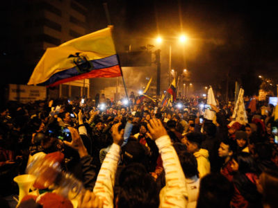 Throngs of people congregate and wave Ecuadorian flags during a protest