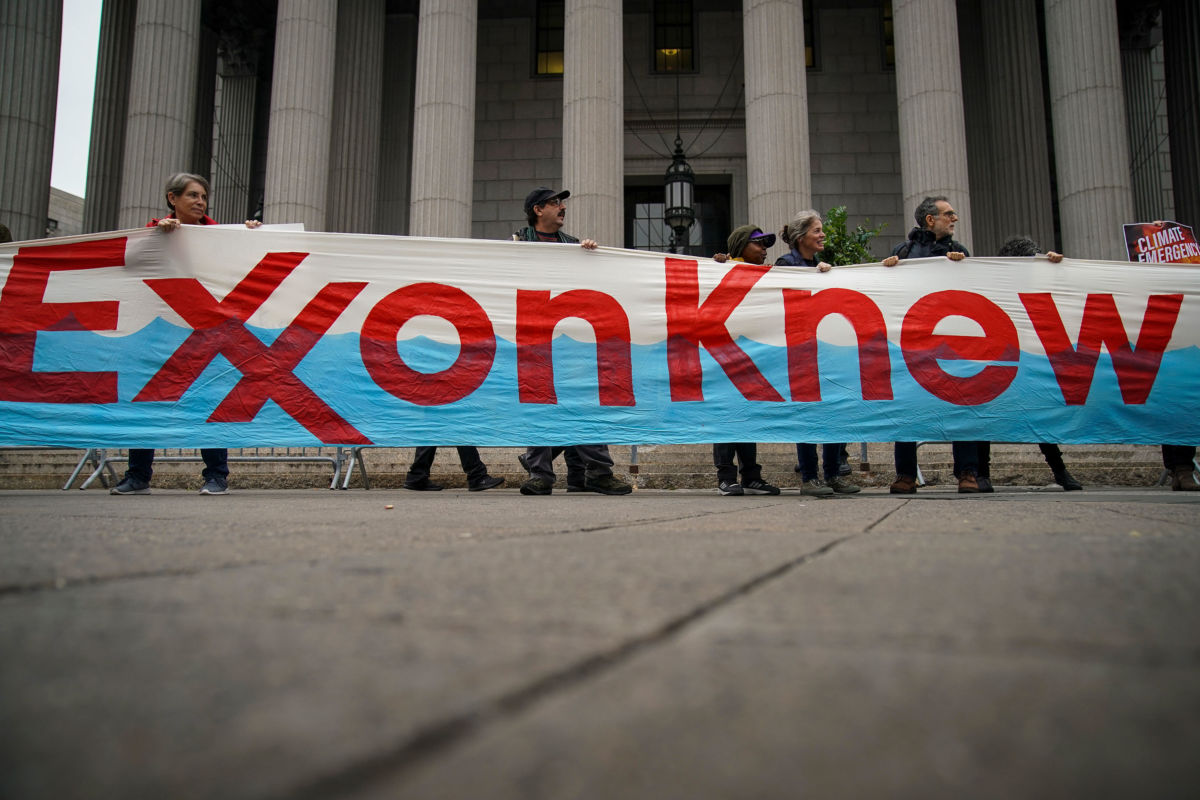 Environmental activists rally outside of New York Supreme Court with a banner reading: Exxon Knew