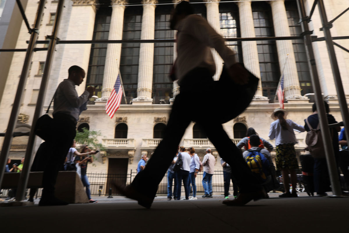 People walk by the New York Stock Exchange on October 1, 2019, in New York City.
