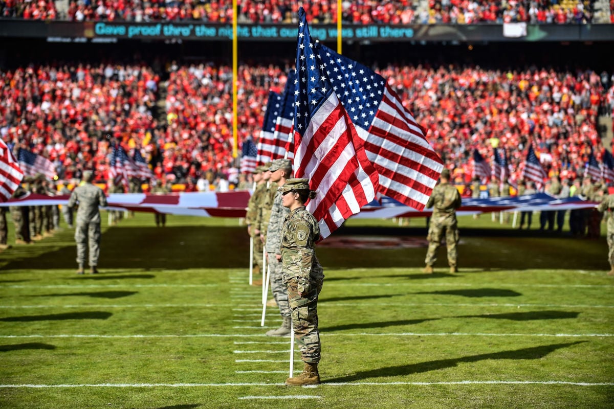 Members of the Armed Forces hold flags on the field during the national anthem ceremony prior to a game at Arrowhead Stadium on November 11, 2018, in Kansas City, Missouri.