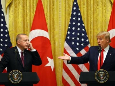 Donald Trump gestures at Tayyip Erdogan as they both stand at podiums