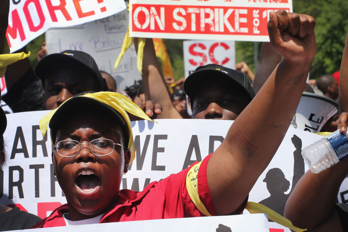 Fast food workers and activists demonstrate outside the McDonald's corporate campus on May 21, 2014, in Oak Brook, Illinois.