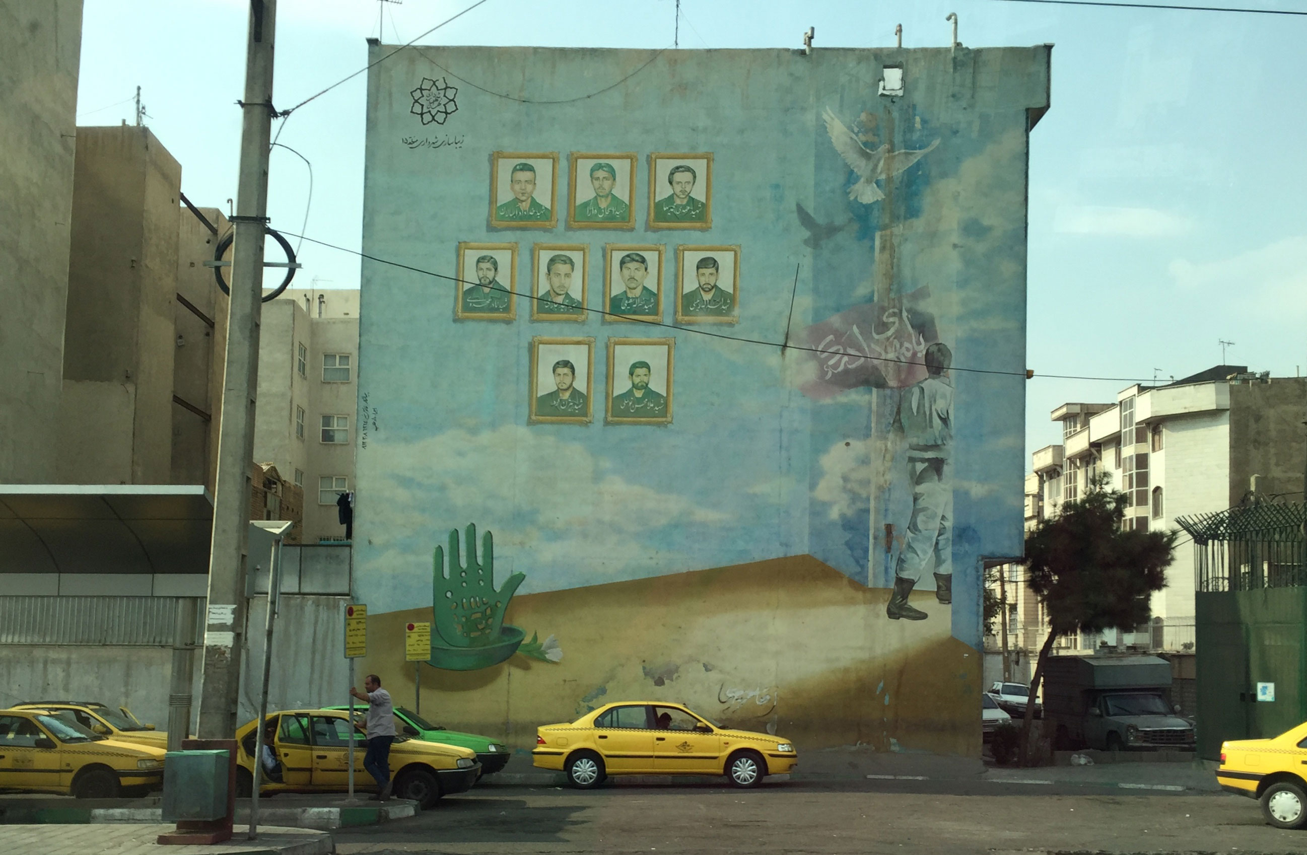 In south Tehran taxis are parked beneath a mural depicting martyrs killed in the Iran-Iraq war (1980-88). Over 30 years after the war ended, such murals are still common in cities across Iran.