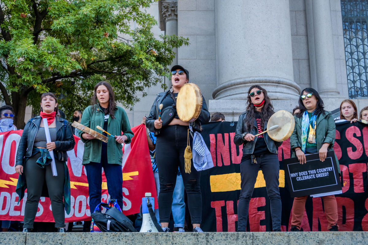 Native American activists play drums and sing during a rally