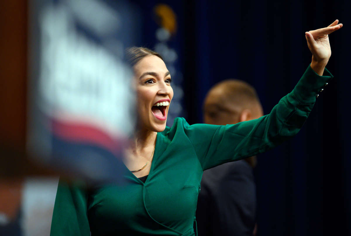 Rep. Alexandria Ocasio-Cortez speaks into a microphone at a rally