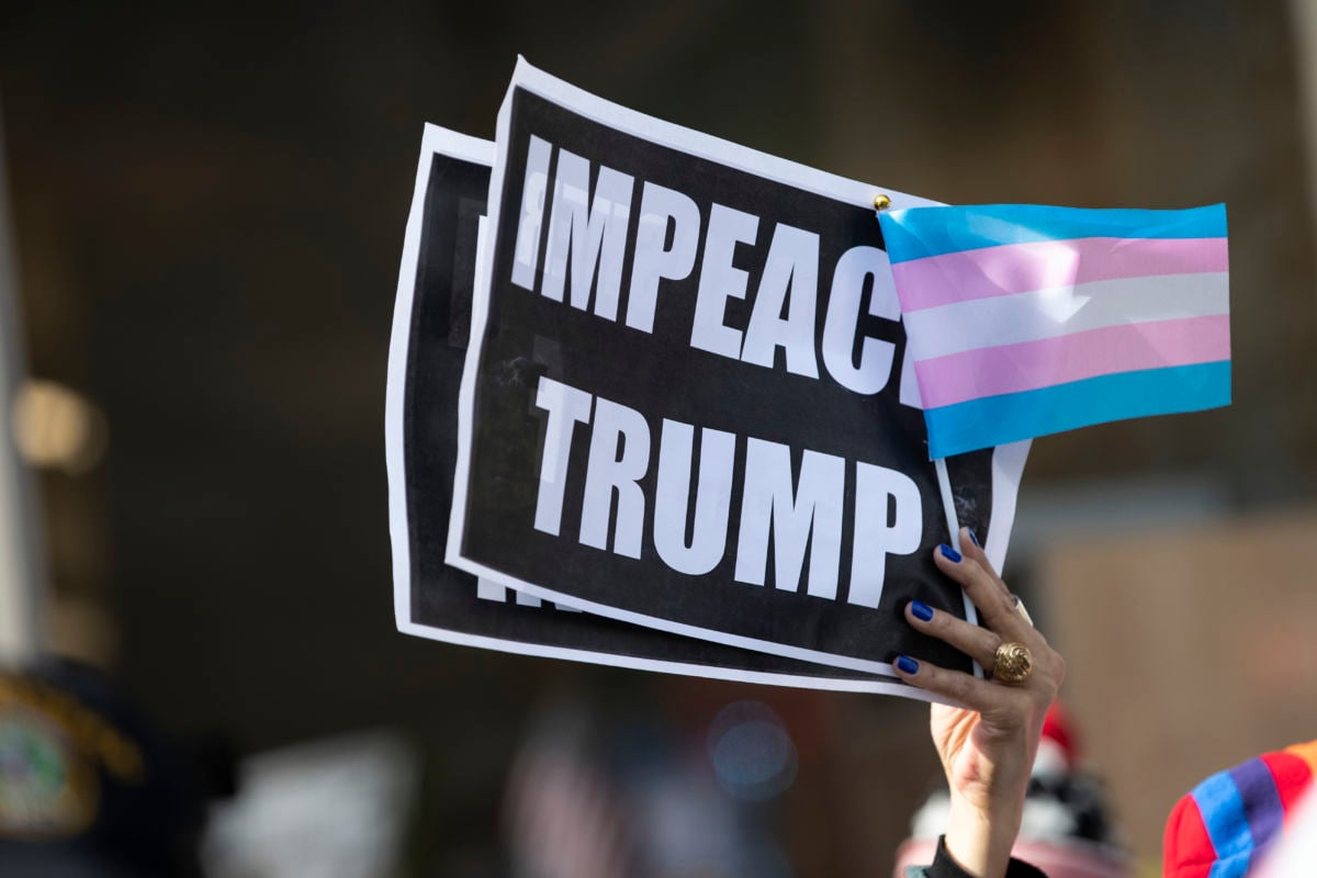 Protesters in support of gay and transgender rights outside on 5th Avenue with signs that say "IMPEACH TRUMP" with a Transgender Pride flag after the 45th President Donald J. Trump gave his opening ceremony of the New York City 100th annual Veterans Day Parade and wreath-lay in New York City on November 11, 2019.