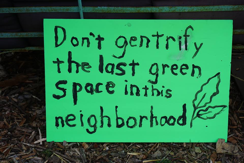 A supporter makes a sign that says “Don’t gentrify the last green space in this neighborhood” to support Bushwick City Farm in 2017.