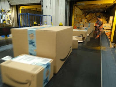 A worker loads a truck with packages at an Amazon packaging center on November 28, 2019, in Brieselang, Germany.