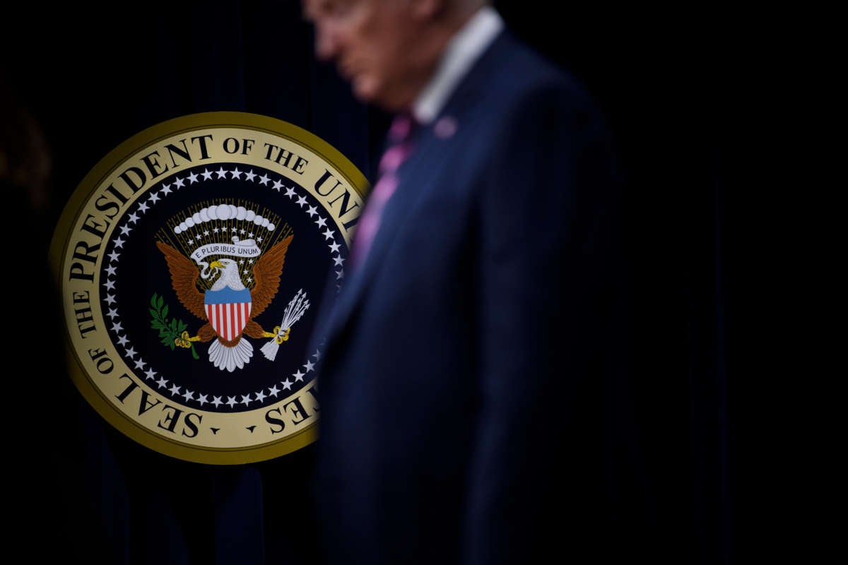 Donald trump stands in front of the seal of the u.s. president