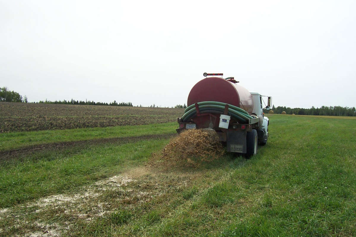 A septic truck spreads waste on farm land.