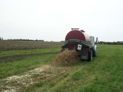 A septic truck spreads waste on farm land.