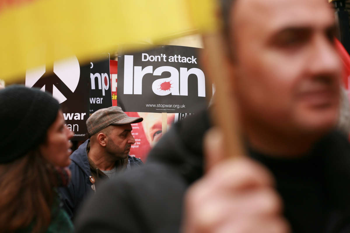 A person holds a sign reading "don't attack Iran" during a protest