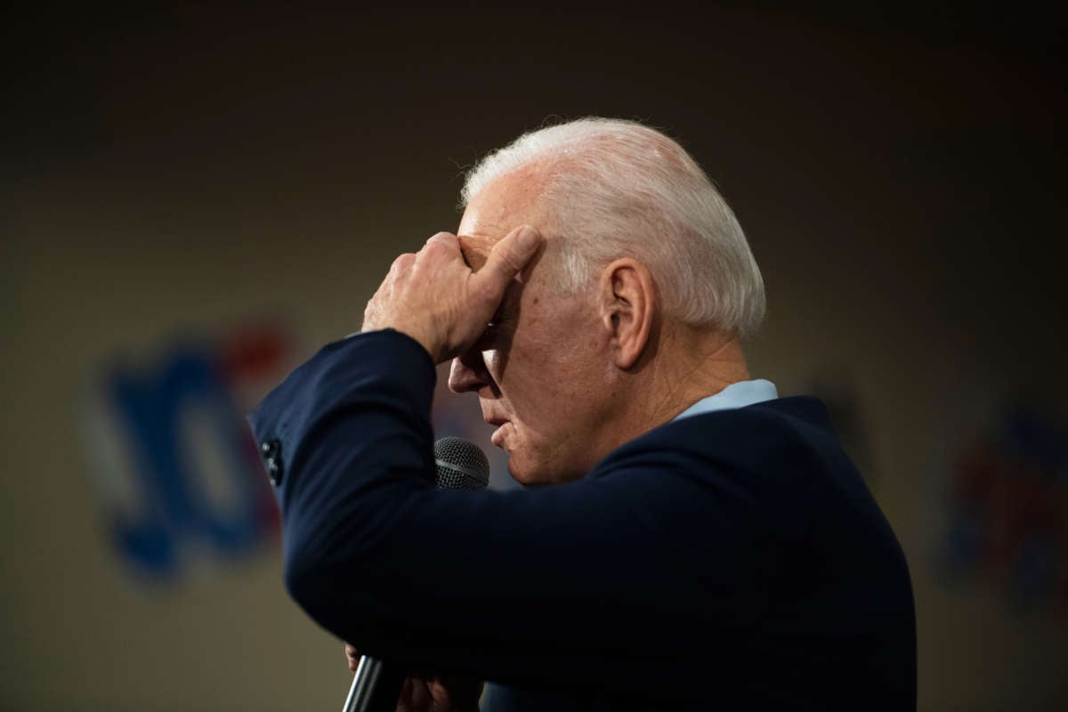 Joe Biden shields his face from light