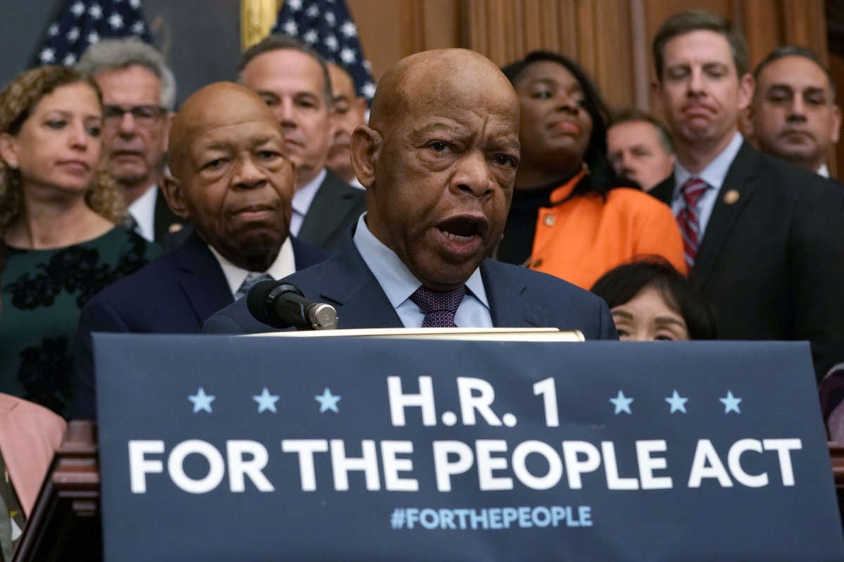 Rep. John Lewis speaks at a podium surrounded by other democrats