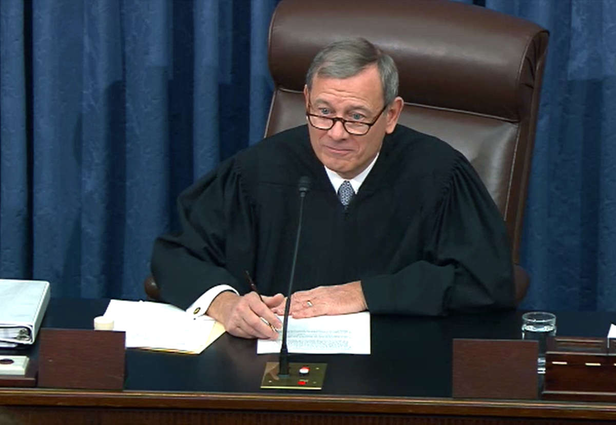 Justice Roberts sits at a desk during a hearing