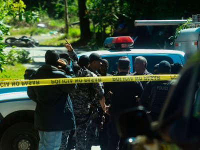 Police investigators work at a crime scene where a member of the National Civil Police was allegedly killed by gang members, in Santa Tecla, El Salvador, on October 17, 2017.