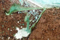 Thermokarst lakes, which result from water released by thawing permafrost, dot the land around Omulyakhskaya and Khromskaya Bays, Northern Siberia, pictured on June 15, 2009.