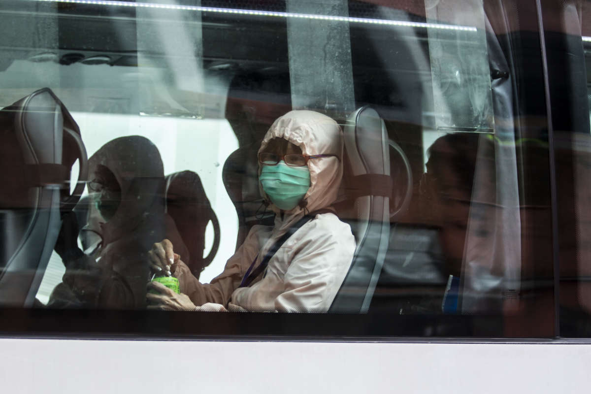 A passenger in a bus wears a face mask