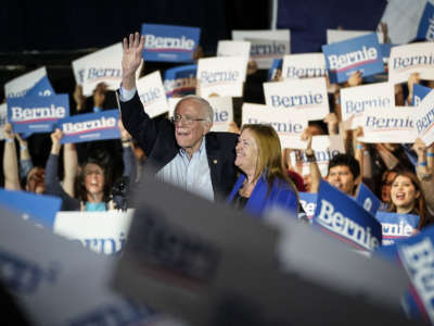 Bernie Sanders stands with his wife at a rally